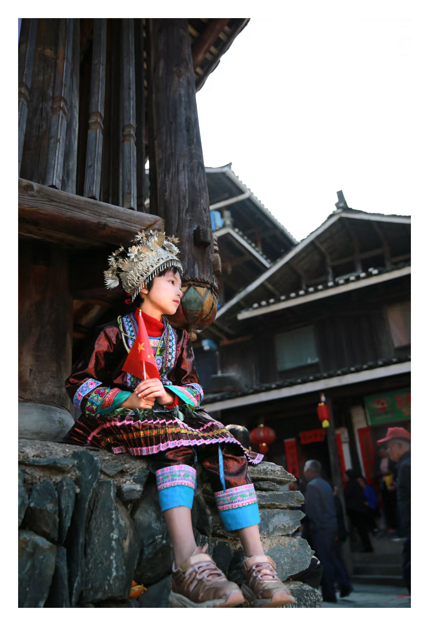 《侗寨红韵:国旗与少年的坚定》